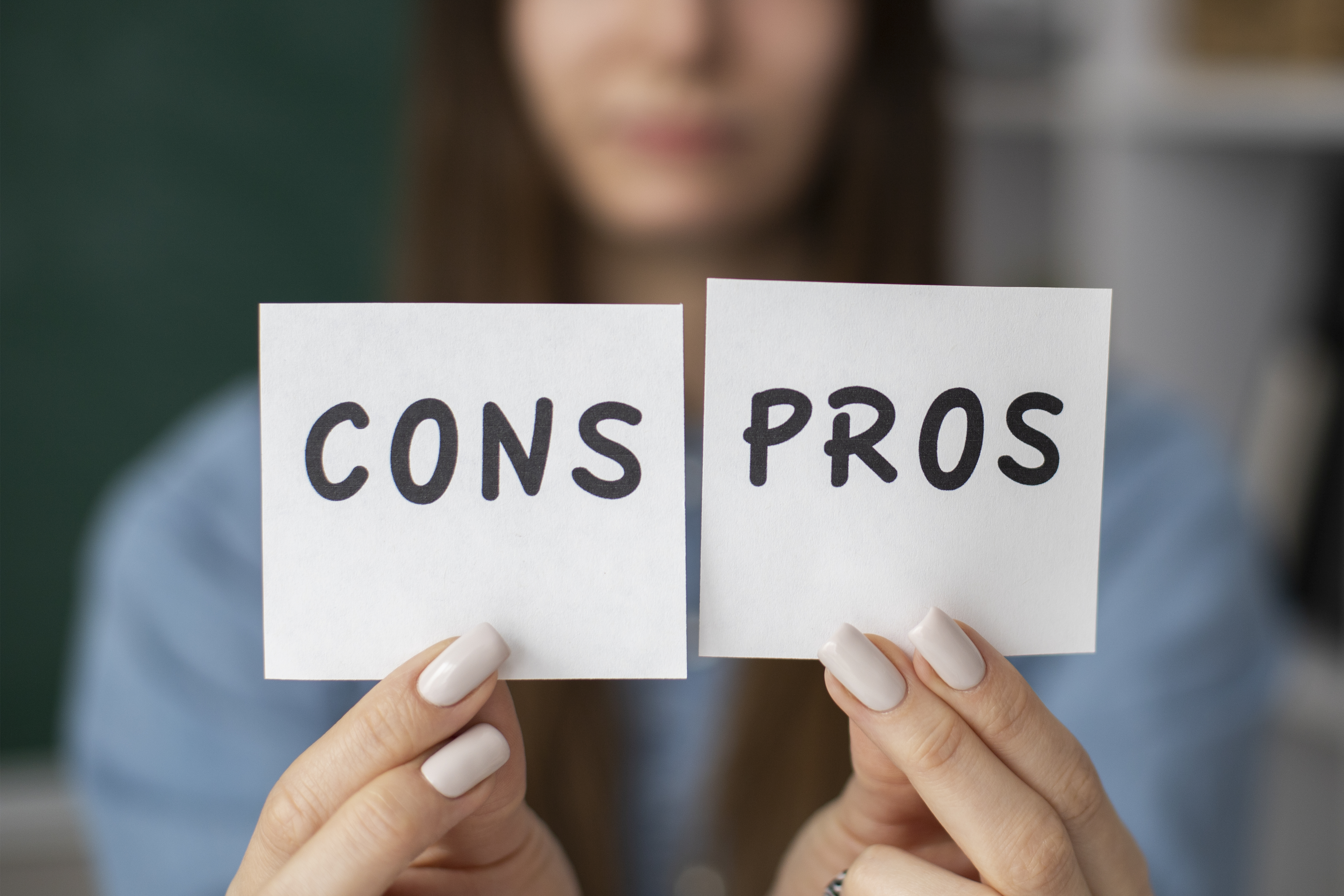 blurry-woman-holding-cons-pros-post-its