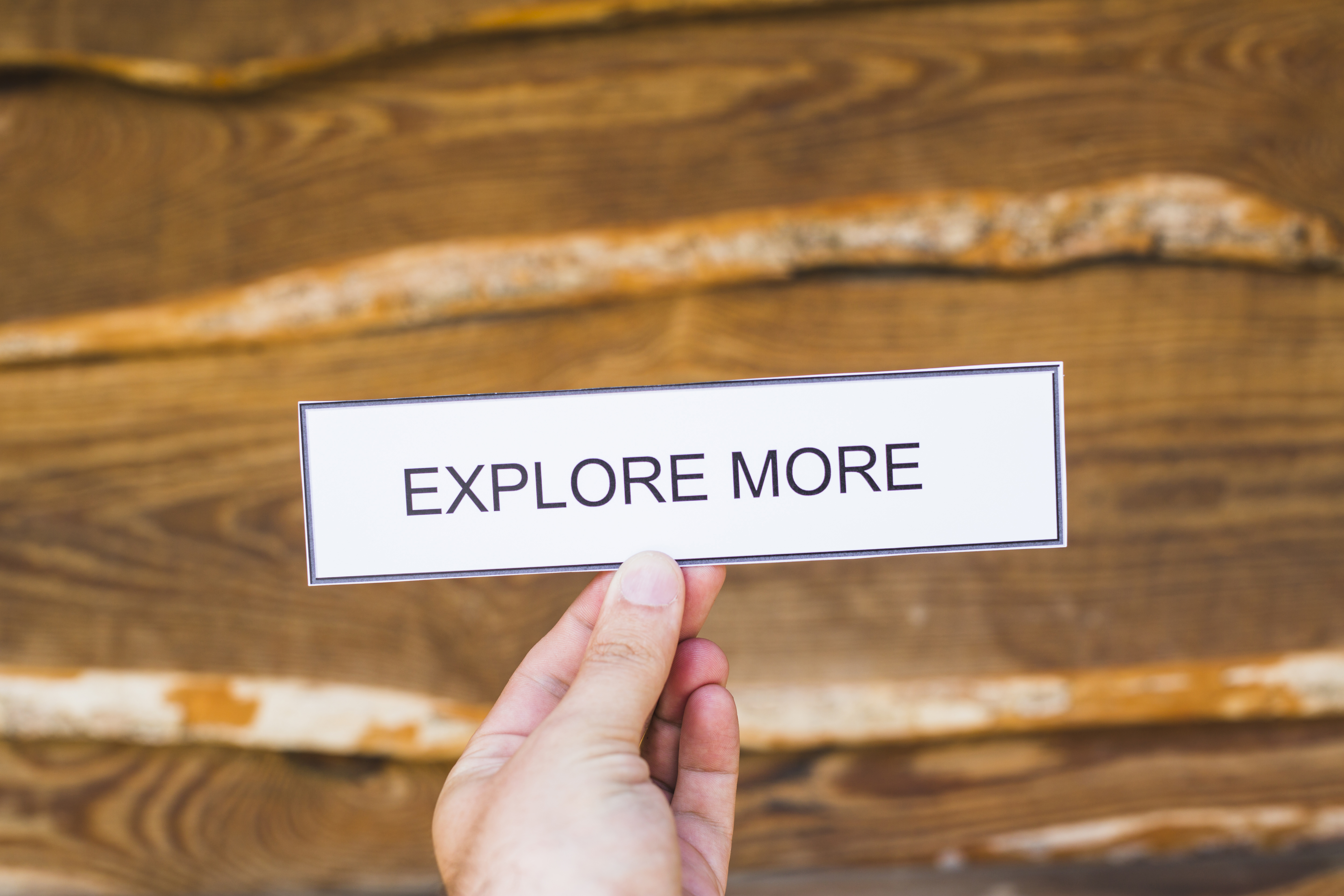 human-hand-holding-paper-with-explore-more-text